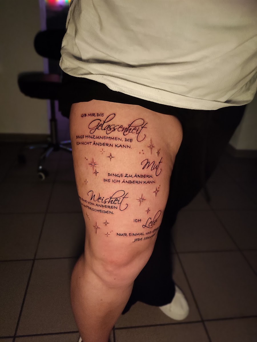 Fine-Line-Schriftzug-Tattoo am Oberschenkel